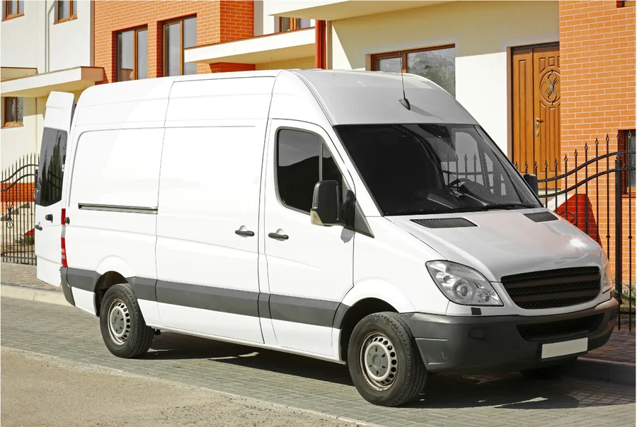 Weisser Transporter, abfahrbereit am Strassenrand vor einem Wohnhaus
